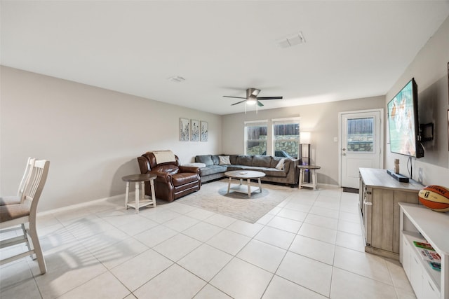 living room featuring baseboards, a ceiling fan, light tile patterned flooring, and visible vents