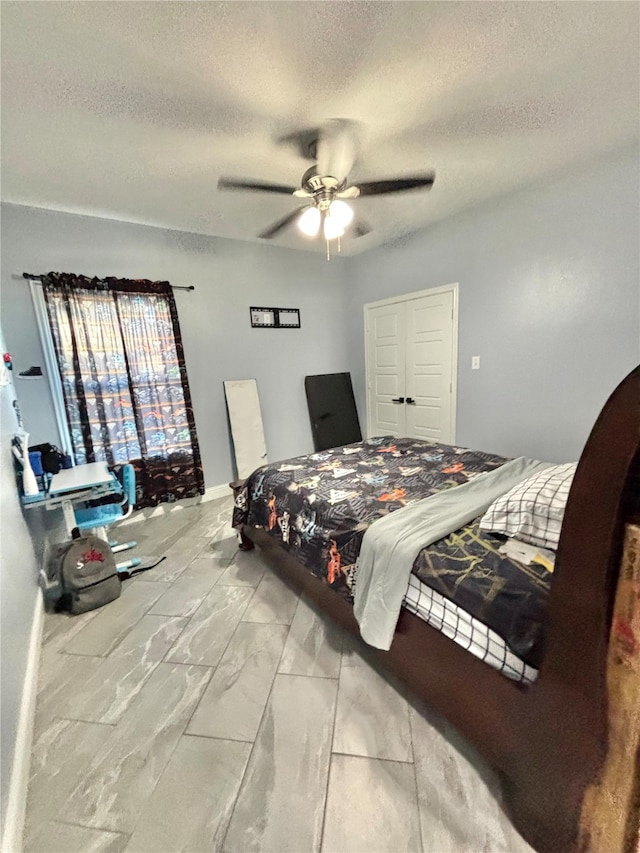 2512 Highcrest Ave, Fort Worth, TX 76111 - bedroom featuring marble look tile flooring, a textured ceiling, and a ceiling fan