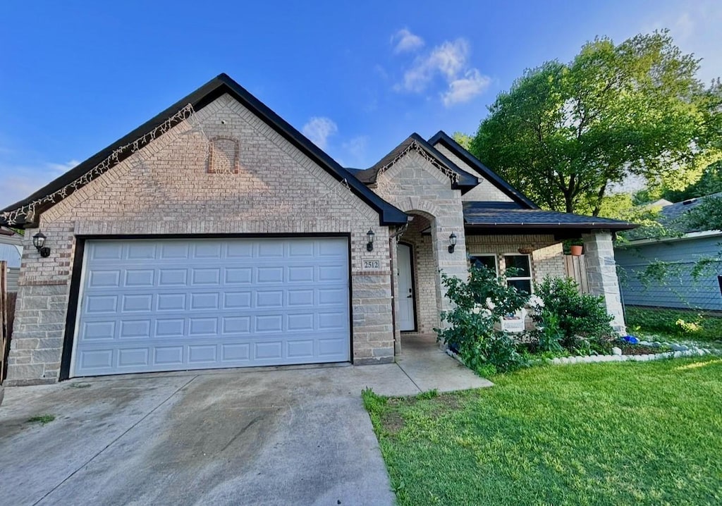 view of front facade featuring a front lawn, stone siding, a garage, brick siding, and driveway