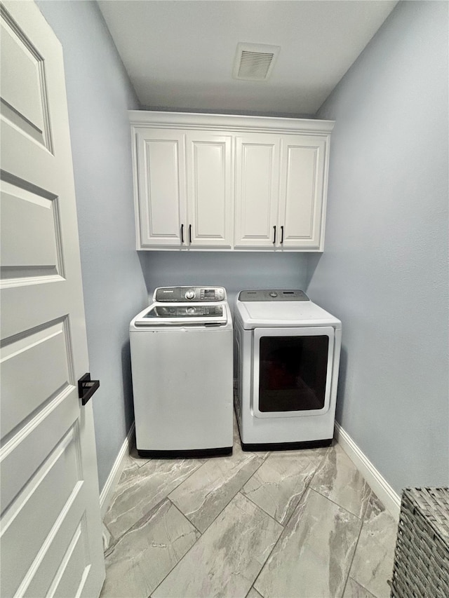 2512 Highcrest Ave, Fort Worth, TX 76111 - laundry room featuring washer and clothes dryer, cabinet space, baseboards, and light marble finish floors