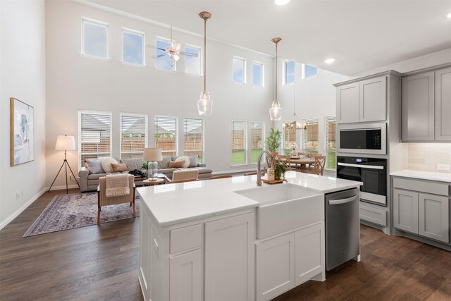 kitchen featuring a sink, gray cabinets, stainless steel dishwasher, and oven