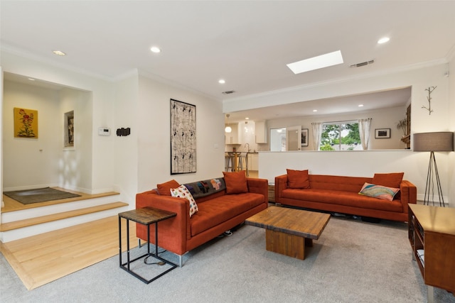 living area with a skylight, ornamental molding, recessed lighting, and visible vents