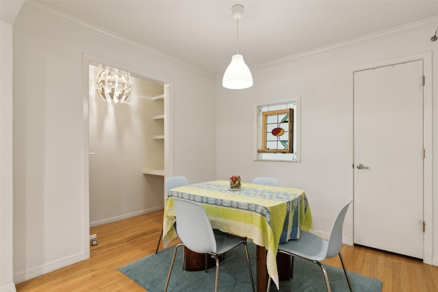 dining room featuring crown molding, baseboards, and wood finished floors