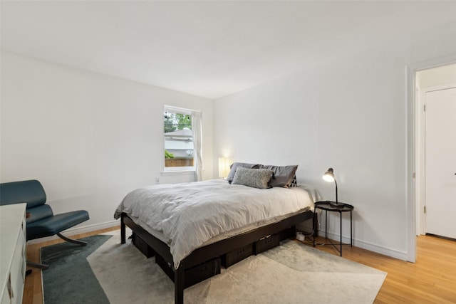 bedroom with light wood-style floors and baseboards