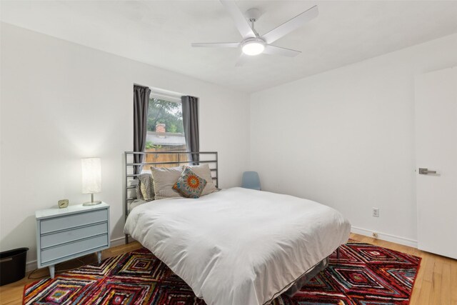 bedroom with baseboards, a ceiling fan, and wood finished floors