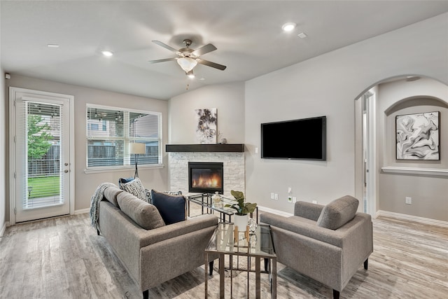 living room featuring baseboards, a ceiling fan, wood finished floors, and a fireplace