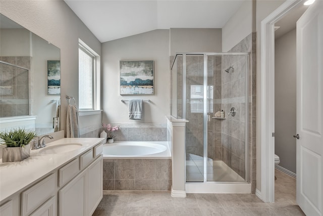 bathroom with a garden tub, vanity, toilet, a shower stall, and vaulted ceiling
