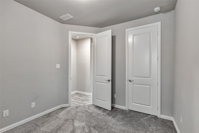 unfurnished bedroom featuring carpet flooring, baseboards, and visible vents