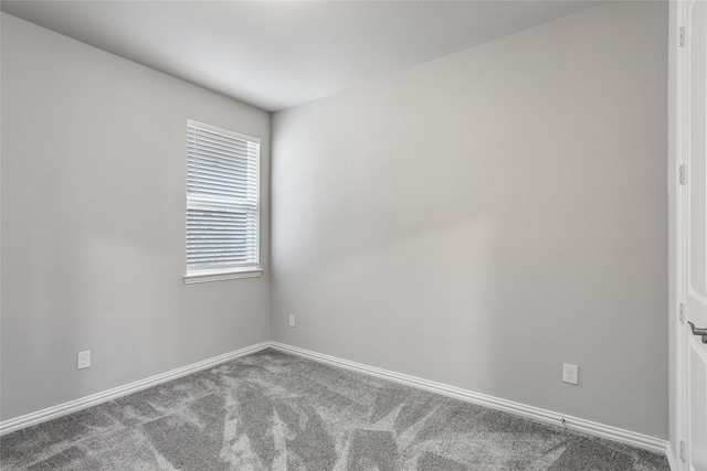 carpeted spare room featuring baseboards