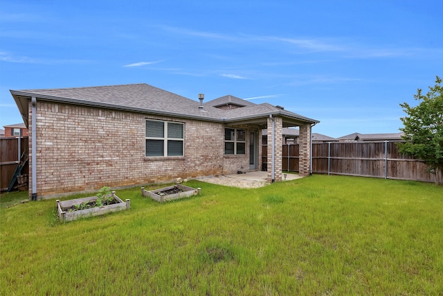 back of property featuring a lawn, a shingled roof, fence, and a vegetable garden