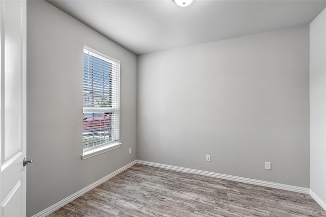spare room with baseboards and light wood-style flooring