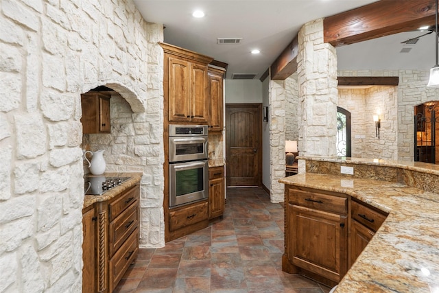 kitchen with black electric cooktop, stone finish flooring, stainless steel double oven, and visible vents
