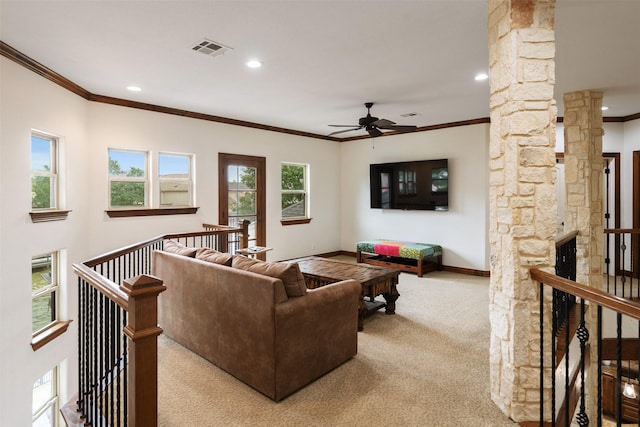 living area with a ceiling fan, decorative columns, visible vents, ornamental molding, and carpet flooring