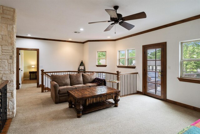 living room with carpet flooring, crown molding, ceiling fan, baseboards, and visible vents