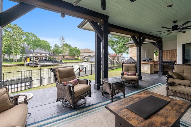 view of patio / terrace with an outdoor hangout area, fence, ceiling fan, and exterior kitchen