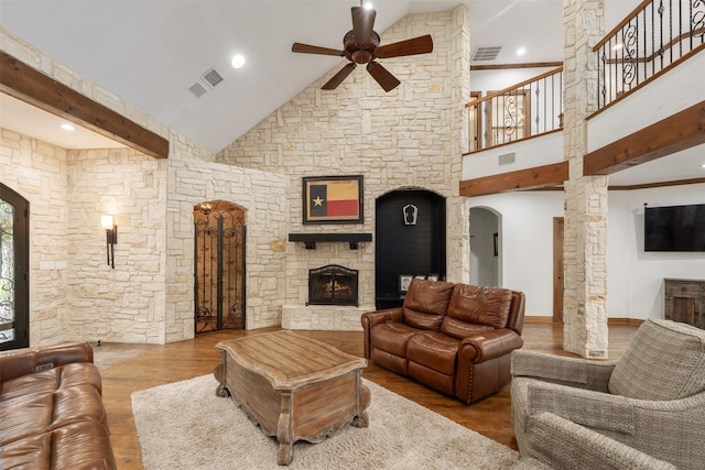 living room with visible vents, ceiling fan, wood finished floors, and a fireplace