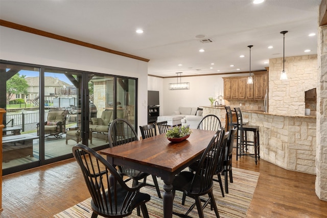 dining area with recessed lighting, ornamental molding, and light wood-type flooring