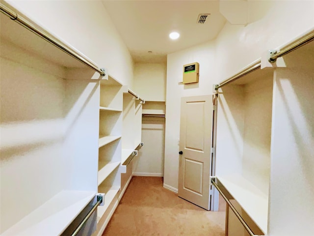 walk in closet with light colored carpet and visible vents