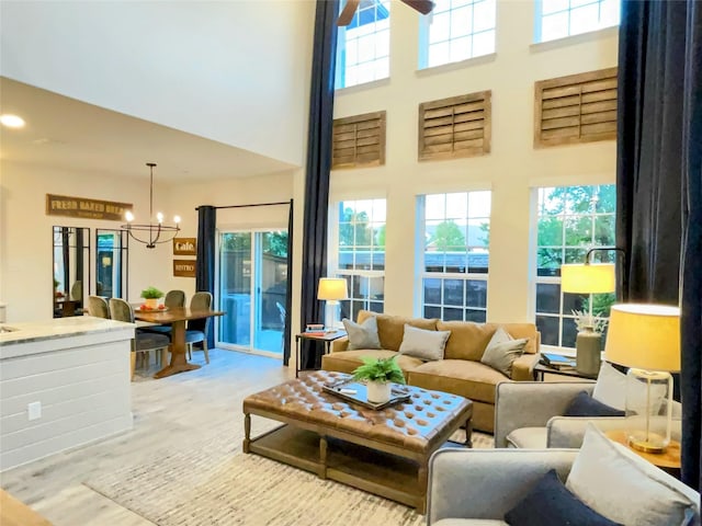 living area featuring an inviting chandelier, a high ceiling, and a wealth of natural light