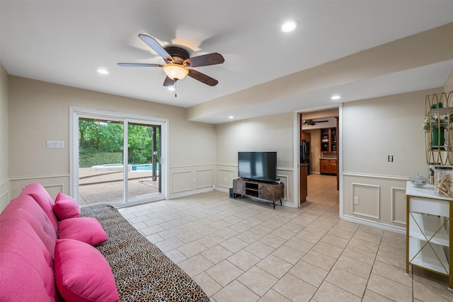 living room featuring a ceiling fan, a wainscoted wall, a decorative wall, recessed lighting, and light tile patterned flooring