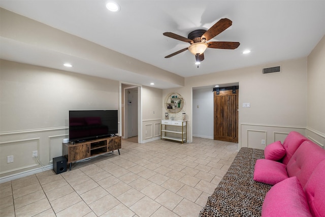 living room with a decorative wall, recessed lighting, and visible vents
