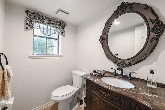bathroom with visible vents, baseboards, toilet, and vanity