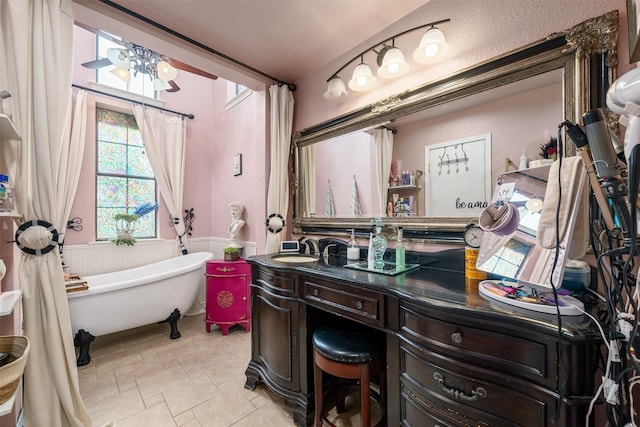 bathroom featuring a freestanding tub, vanity, an inviting chandelier, and wainscoting