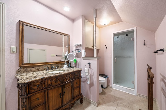 bathroom with vanity, toilet, a textured ceiling, vaulted ceiling, and a stall shower