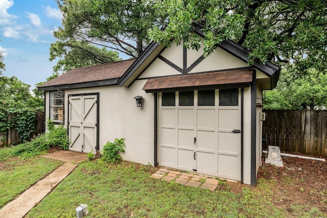 garage with fence and a shed
