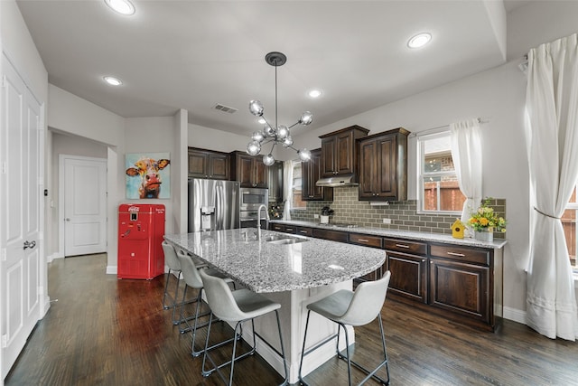 3608 Delta Dr, Mckinney, TX 75071 - kitchen with stainless steel appliances, dark brown cabinetry, under cabinet range hood, a sink, and dark wood-type flooring
