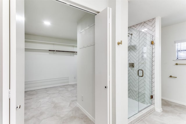 full bathroom with a shower stall and a walk in closet
