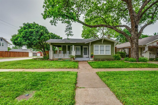 single story home with a porch, a front lawn, and a chimney