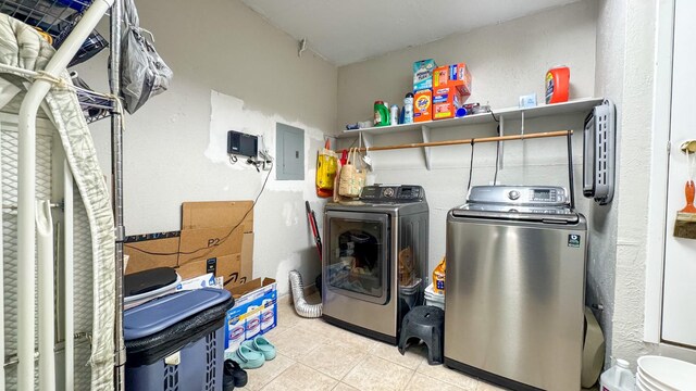 laundry room with light tile patterned floors, electric panel, laundry area, and washing machine and clothes dryer