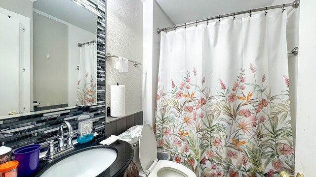 bathroom featuring vanity, decorative backsplash, and toilet