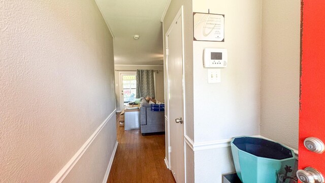 corridor with a textured wall and wood finished floors