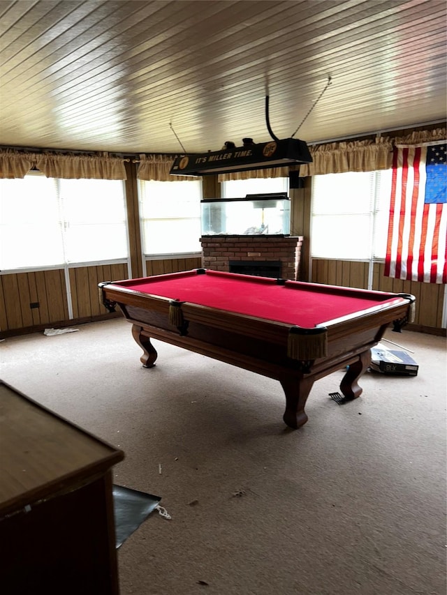 game room featuring wooden walls, billiards, carpet, and a brick fireplace