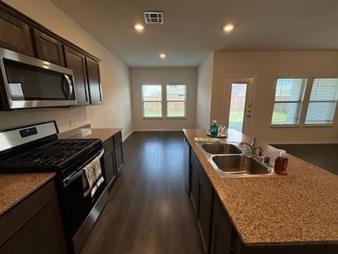 1109 Colonial Bluff Ln, Princeton, TX 75407 - kitchen featuring visible vents, a kitchen island with sink, dark wood-style floors, a sink, and appliances with stainless steel finishes