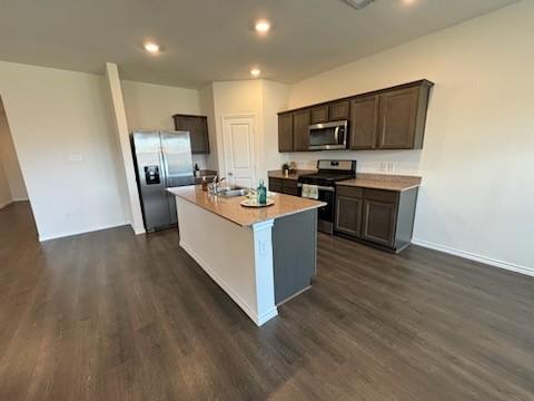 1109 Colonial Bluff Ln, Princeton, TX 75407 - kitchen featuring dark brown cabinetry, a center island with sink, stainless steel appliances, recessed lighting, and dark wood-style floors