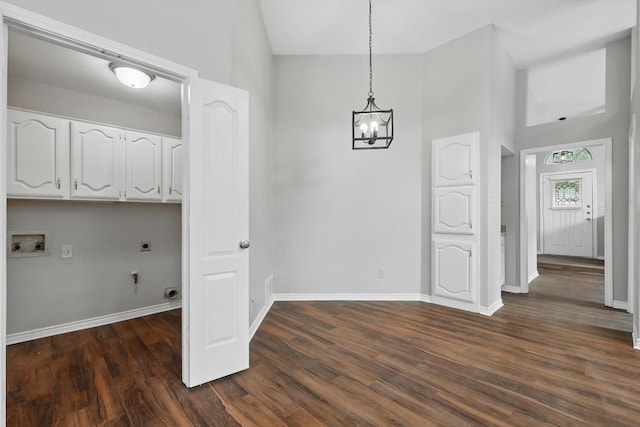 unfurnished dining area featuring baseboards, a notable chandelier, high vaulted ceiling, and dark wood-type flooring