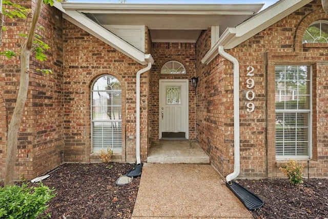 entrance to property featuring brick siding