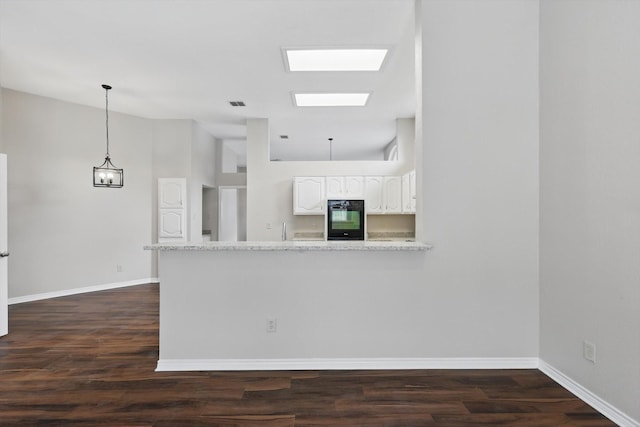 kitchen with white cabinetry, baseboards, dark wood-style floors, and a peninsula