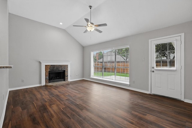 unfurnished living room with a fireplace with raised hearth, dark wood finished floors, a ceiling fan, baseboards, and lofted ceiling