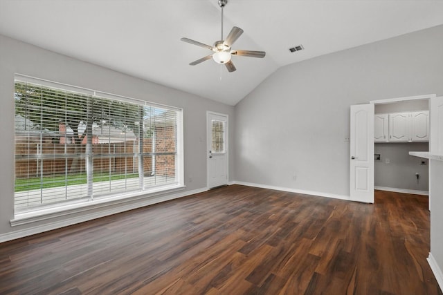 empty room featuring ceiling fan, visible vents, baseboards, lofted ceiling, and dark wood-type flooring