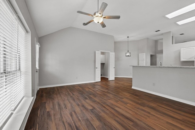 unfurnished living room featuring ceiling fan, dark wood finished floors, a sink, baseboards, and lofted ceiling
