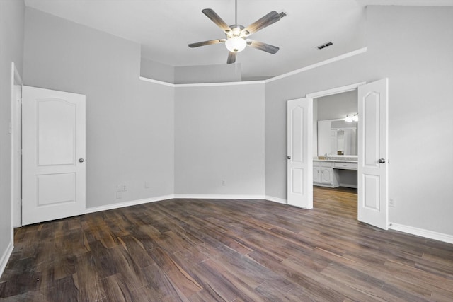 unfurnished bedroom with baseboards, ensuite bathroom, wood finished floors, and visible vents