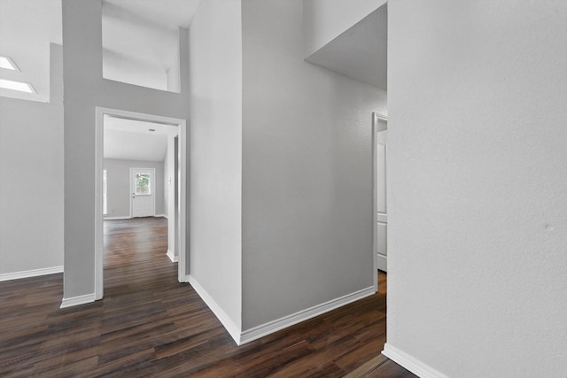hallway with baseboards and dark wood finished floors