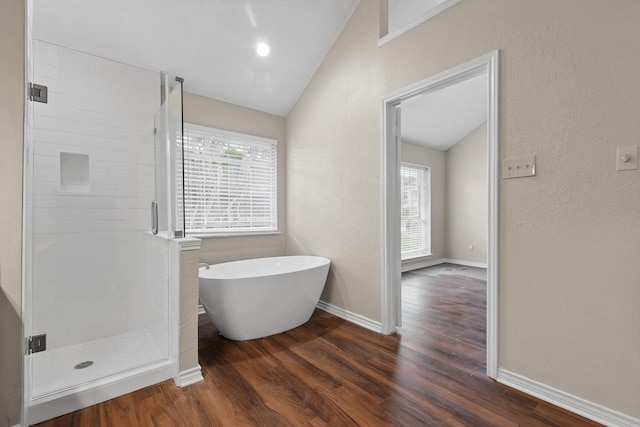 full bath with plenty of natural light, wood finished floors, and lofted ceiling