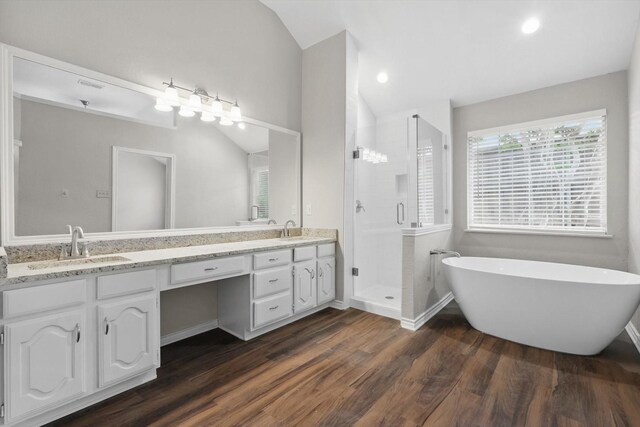 bathroom with a sink, double vanity, wood finished floors, and lofted ceiling