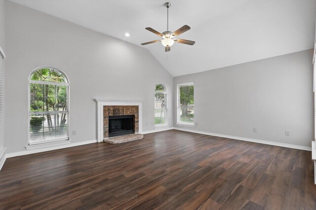 unfurnished living room featuring a tiled fireplace, high vaulted ceiling, a ceiling fan, and dark wood-style floors