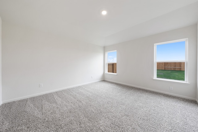 carpeted spare room featuring baseboards